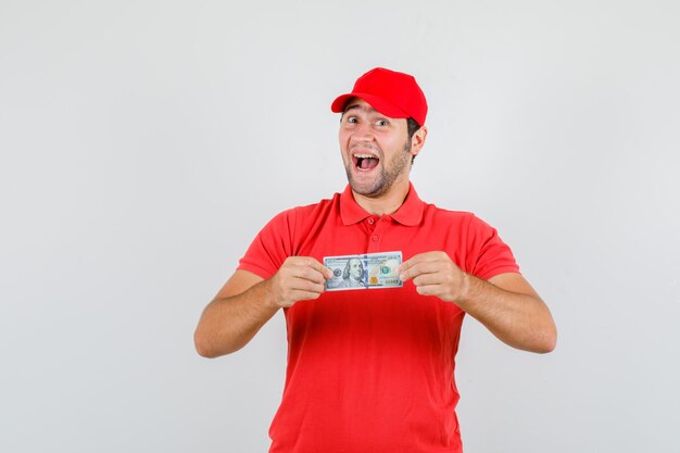 Delivery man holding dollar banknote in red t-shirt