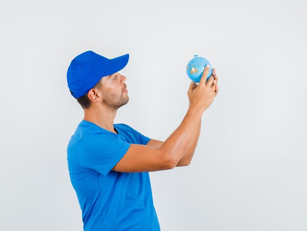 Доставщик, держащий глобус в синей футболке