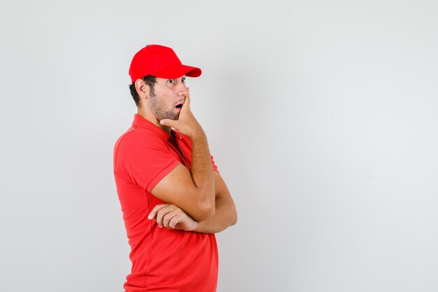 Delivery man holding hand on mouth in red t-shirt