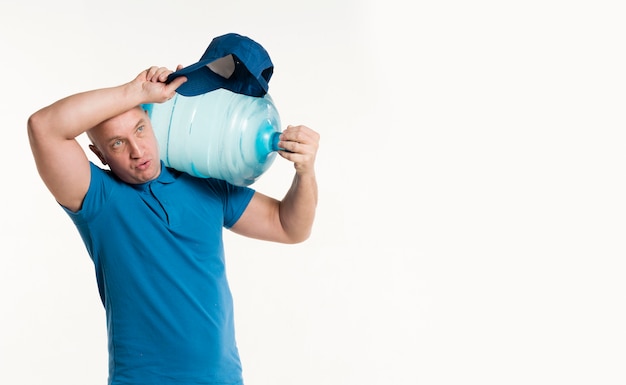 Free photo delivery man holding heavy water bottle