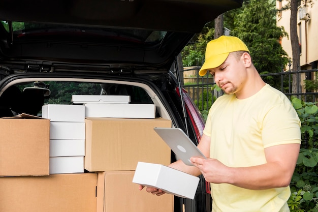 Free photo delivery man holding tablet