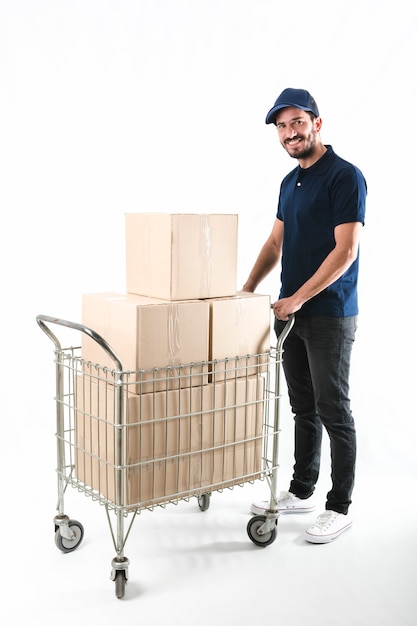 Delivery man holding trolley with cardboard boxes