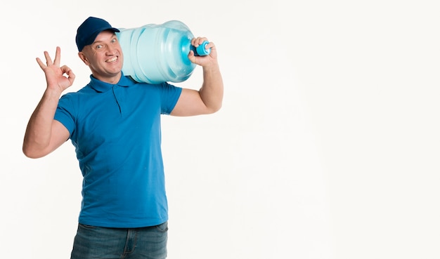 Delivery man holding water bottle and making okay sign