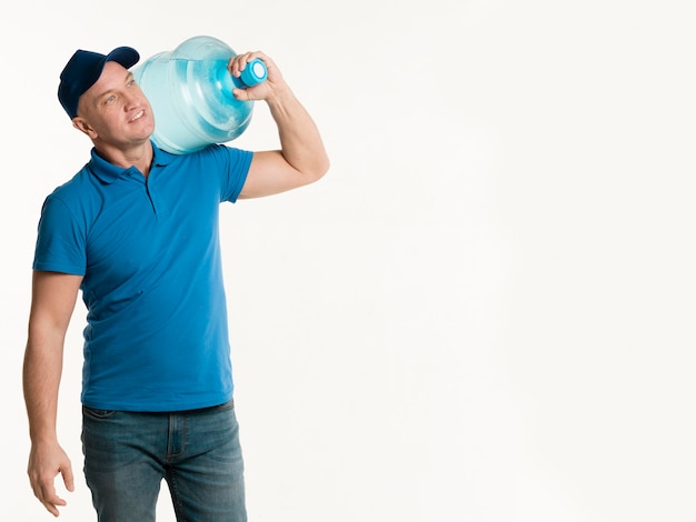 Delivery man holding water bottle with copy space