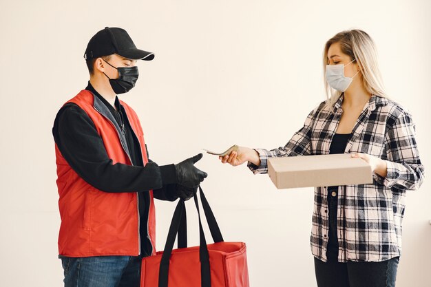 Delivery man in a medic mask with woman