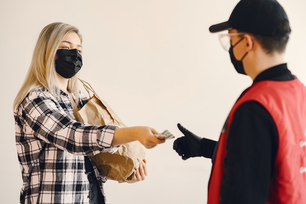 Foto gratuita uomo di consegna in una maschera medica con donna