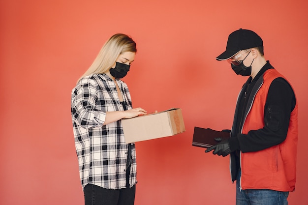 Free photo delivery man in a medic mask with woman