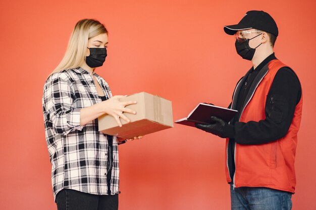 Delivery man in a medic mask with woman