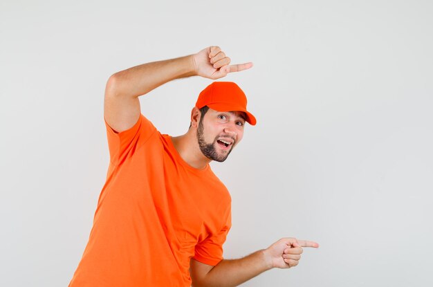주황색 티셔츠를 입은 배달원, 모자가 옆을 가리키고 쾌활한 앞모습.
