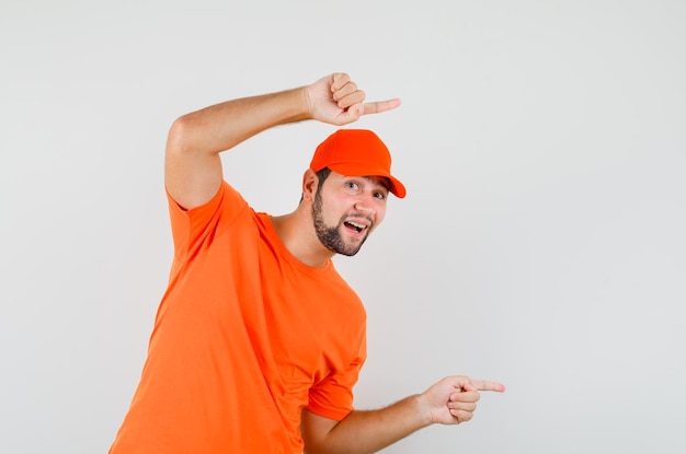 Курьер в оранжевой футболке, кепка указывает в сторону и выглядит веселым, вид спереди.