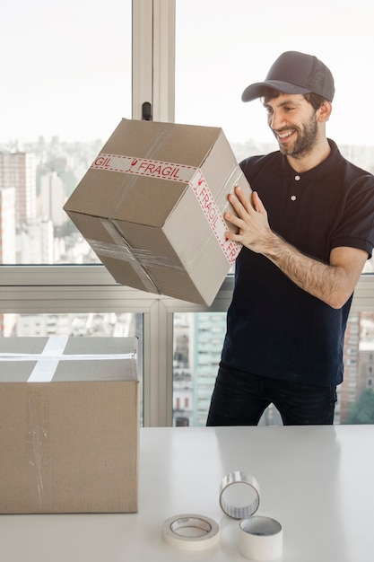 Delivery man packing parcel for shipment to clients