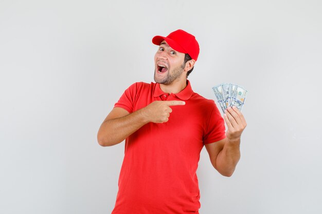 赤いTシャツでドル紙幣を指している配達人