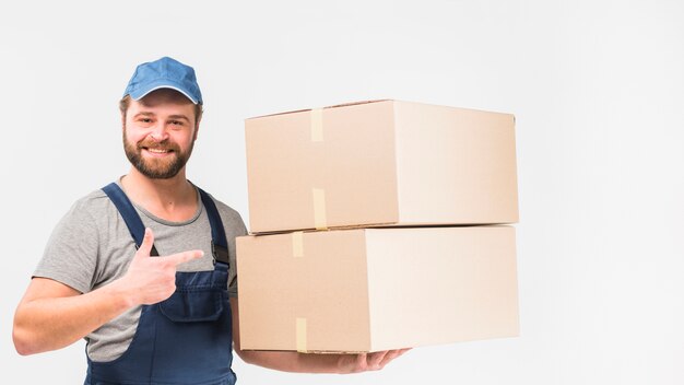 Delivery man pointing finger at boxes