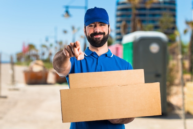 Free photo delivery man pointing to the front