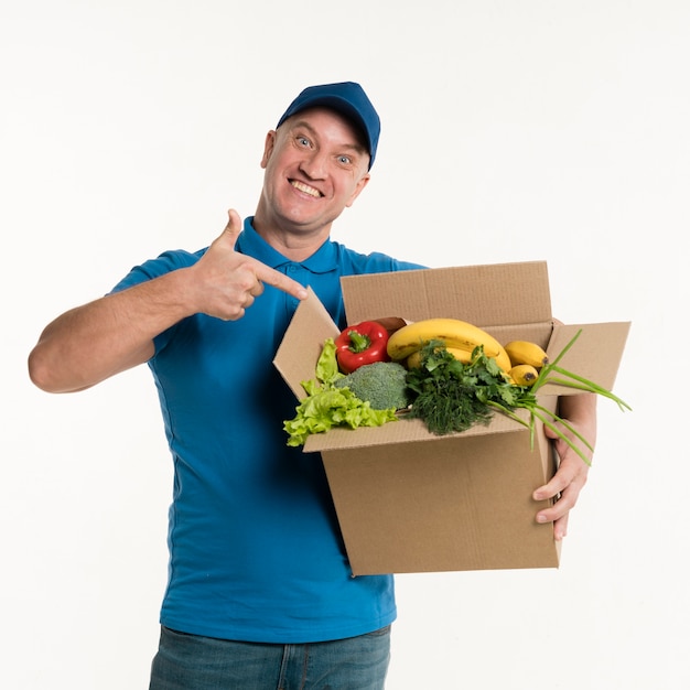 Delivery man pointing to grocery box