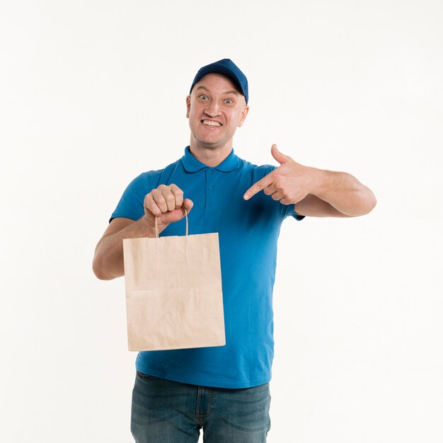 Delivery man pointing at paper bag