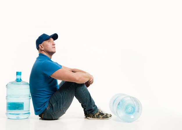 Delivery man posing with water bottles and copy space