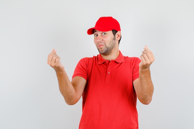 Free photo delivery man in red t-shirt, cap making korean love sign