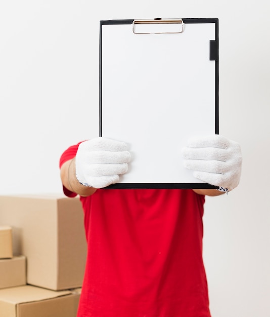 Free photo delivery man showing clipboard