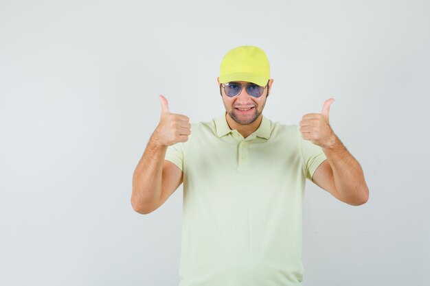 Delivery man showing double thumbs up in yellow uniform and looking cheery. front view.