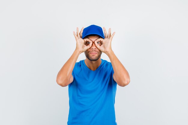 Delivery man showing glasses gesture in blue t-shirt