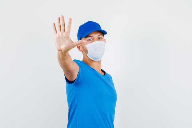 Delivery man showing stop gesture with hand in blue t-shirt