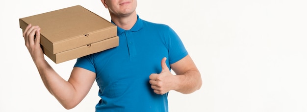 Delivery man showing thumbs up while carrying pizza boxes