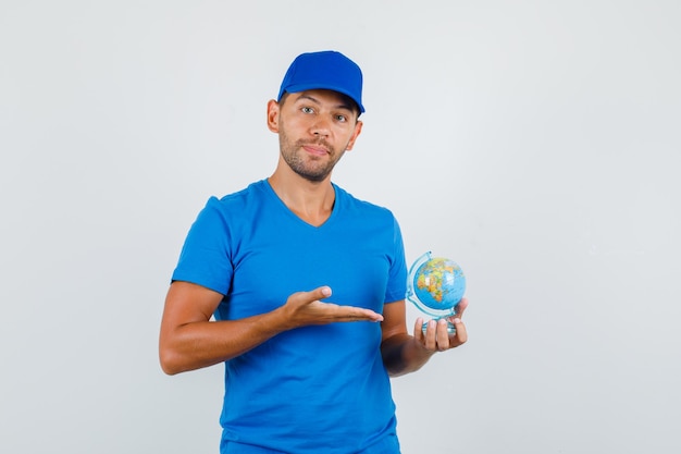 파란색 티셔츠에 세계 세계를 보여주는 배달 남자