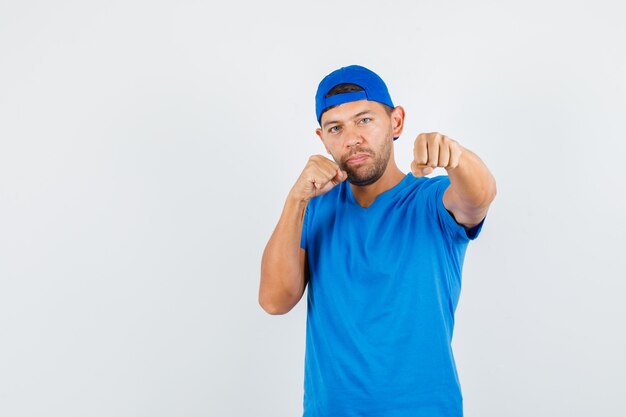 Delivery man standing in boxer pose in blue t-shirt