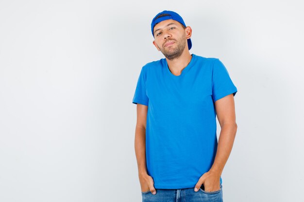 Delivery man standing with hands in pockets in blue t-shirt
