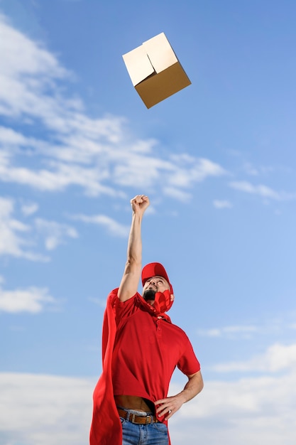 Delivery man throwing parcel in the air