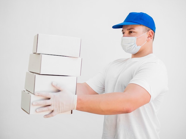 Foto gratuita uomo di consegna che indossa una maschera medica