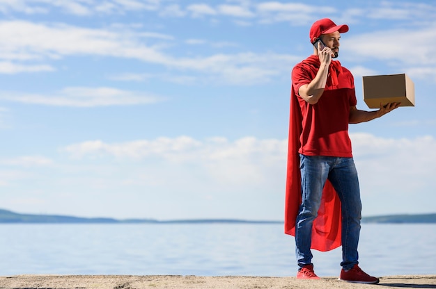 Free photo delivery man wearing superhero cape outdoors