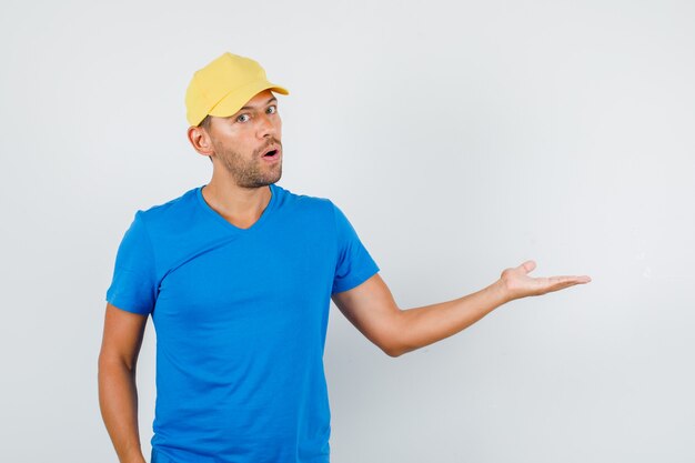 Delivery man welcoming or showing something in blue t-shirt