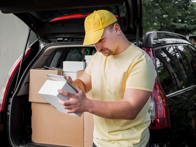 Delivery man with box and tablet