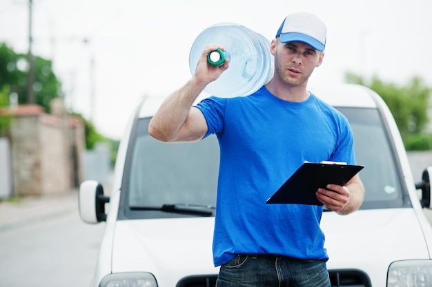 Delivery man with clipboard in front cargo van delivering bottles of water