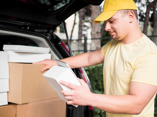 Free photo delivery man with device and box