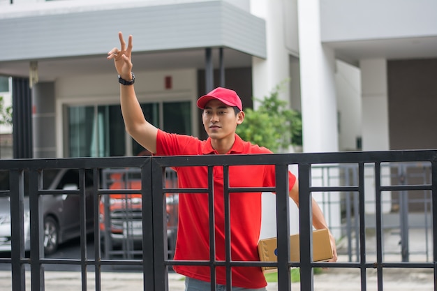 Delivery man with parcel in front of customer home.