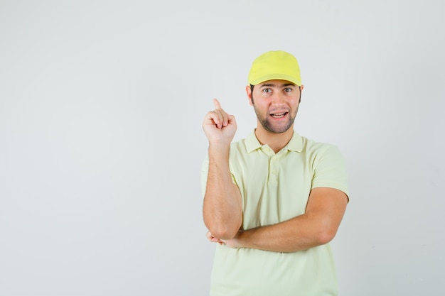 Delivery man in yellow uniform pointing up and looking confident , front view.