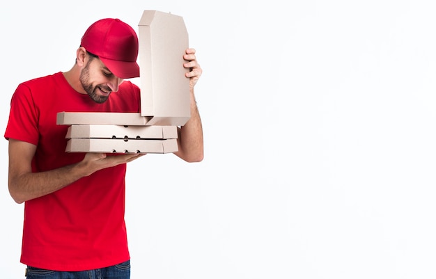 Ragazzo della pizza di consegna che guarda dentro le scatole