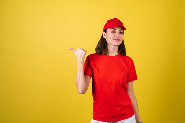 Женщина работника службы доставки в красной форме указывает пальцем налево