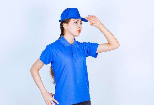 파란색 유니폼을 입고 서서 포즈를 취하는 배달 여성 직원.