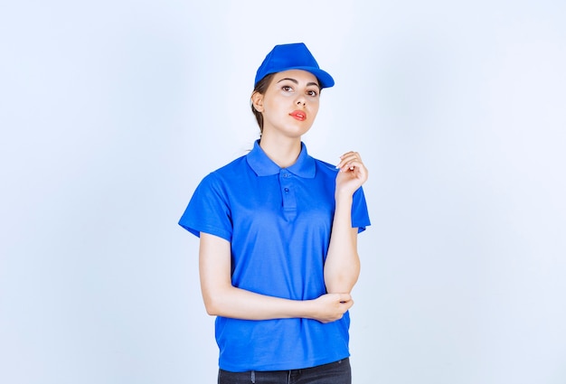 Delivery woman employee in blue uniform standing and posing.