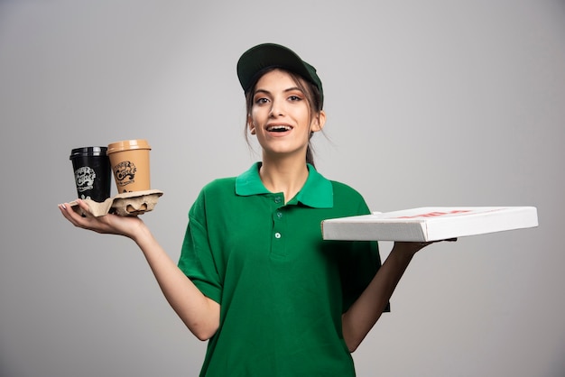 Foto gratuita donna di consegna che dà la scatola della pizza al cliente