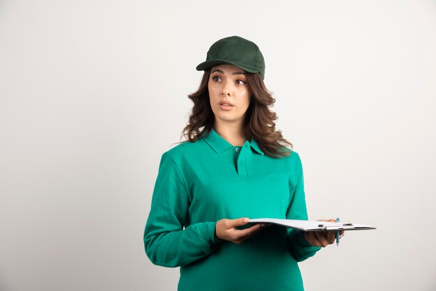 Free photo delivery woman holding clipboard on white.