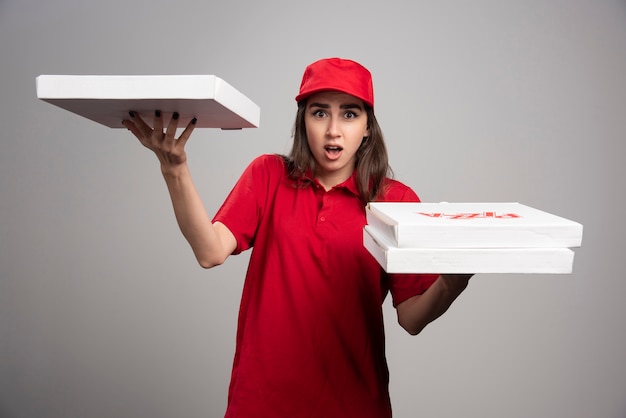 Free photo delivery woman posing with pizza orders.