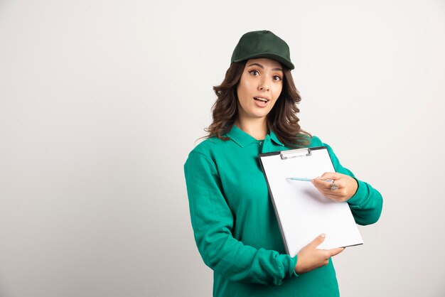 Delivery woman showing order detail with surprised expression.