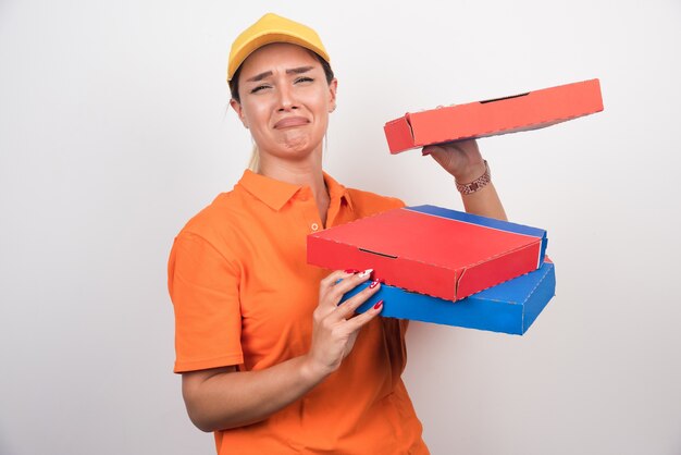 Delivery woman with bored expression holding pizza boxes on white space