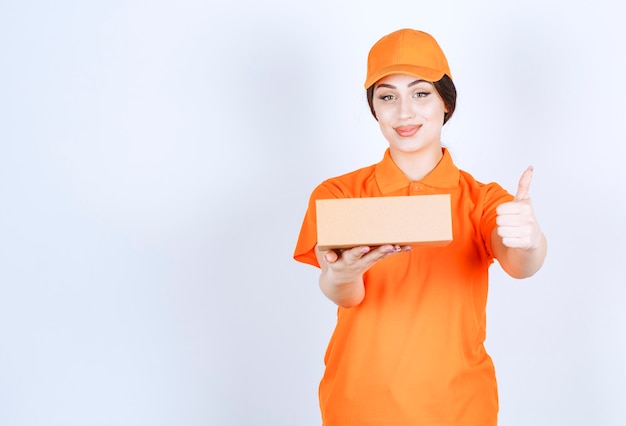 Delivery woman with box gesturing thumb up