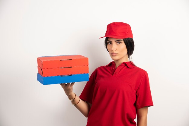 Free photo delivery woman with pizza standing on white background.